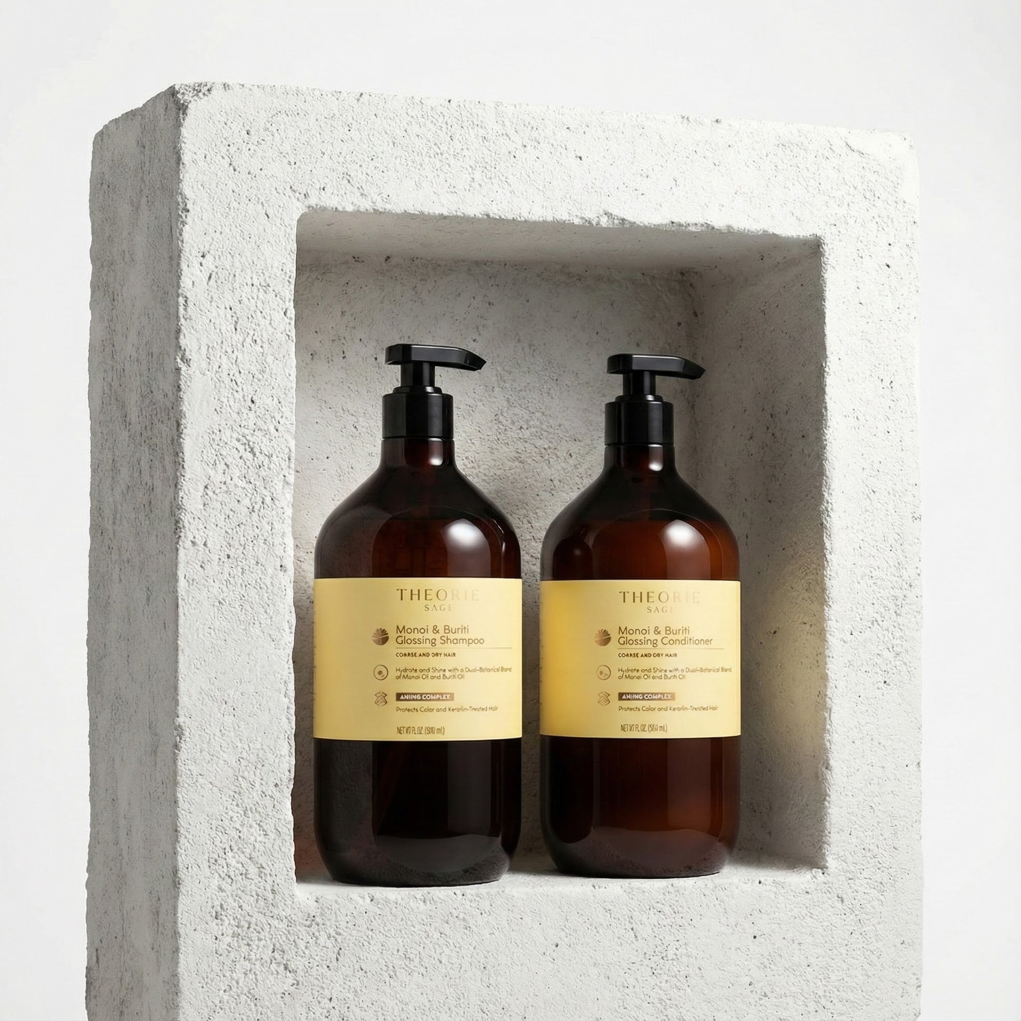 Two brown bottles with black pumps and yellow labels on a concrete surface, Monoi & Buriti Shampoo and Conditioner